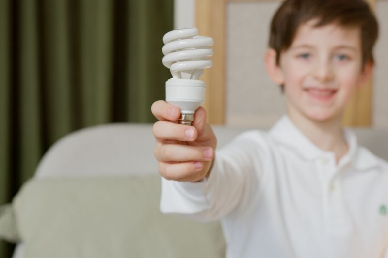 a boy holding an LED light bulb